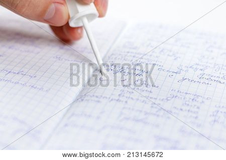 Hand Holding White Corrector For Text In The Notebook. Causes Concealer On Handwritten Text. Isolate