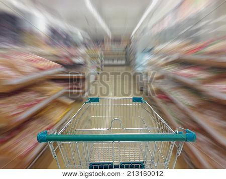 Supermarket aisle with empty shopping cart Supermarket store abstract blurred background with shopping cart.