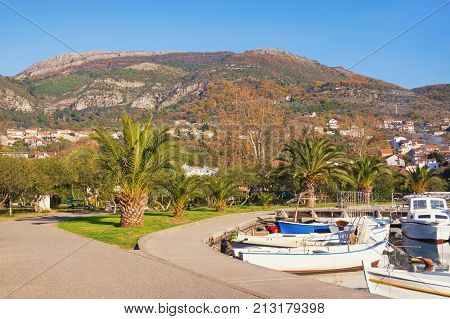 Calm sunny winter day in Mediterranean town of Tivat. View of footpaths and small park near marina Kalimanj. Montenegro