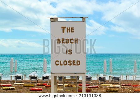 Pointer on the beach with a warning the beach is closed.
