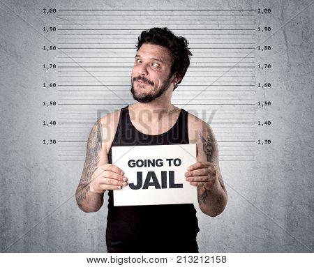 Caugth offender in front of a wall with table in his hand.
