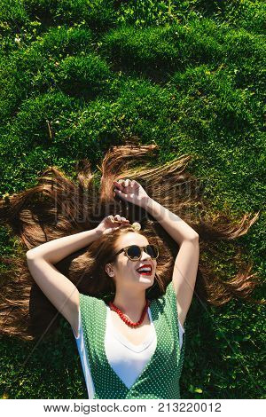Helthy hairs,teeth,smile young girl on the grass,view above,shine woman