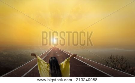 Women rare view on long paveway road aboved blurred top city view with crucifix or cross at way end