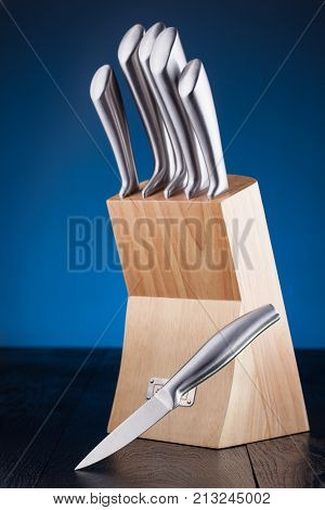 steel knifes in wooden block on the blue background