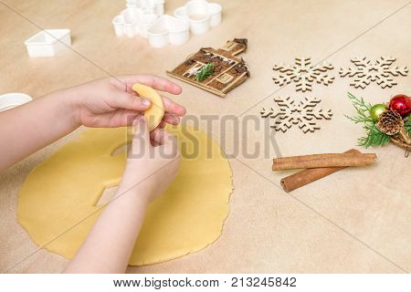 Children's hands make christmas cookies. Children's hands holding cookies of raw dough for christmas