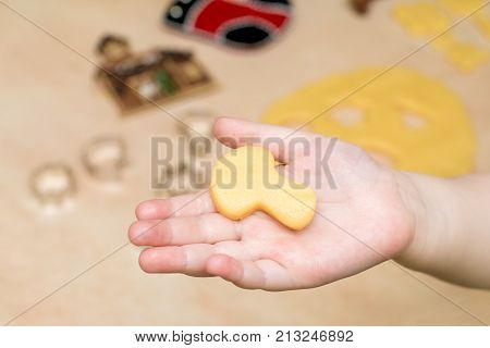 Children's hands make christmas cookies. Children's hands holding cookies of raw dough for christmas