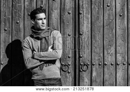Handsome Man Wearing Winter Clothes In Wooden Background.