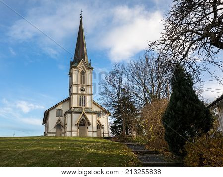 Lillesand, Norway - November 10, 2017: The Church In Lillesand. Front View. Blue Sky, Clouds, Green
