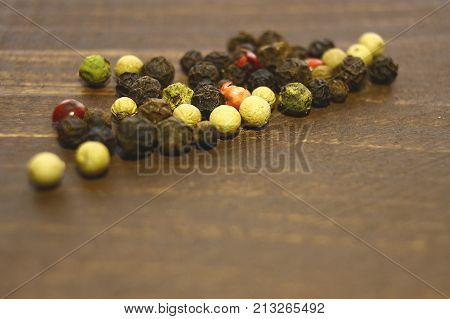Different Kinds Of Pepper Are Scattered On The Table.