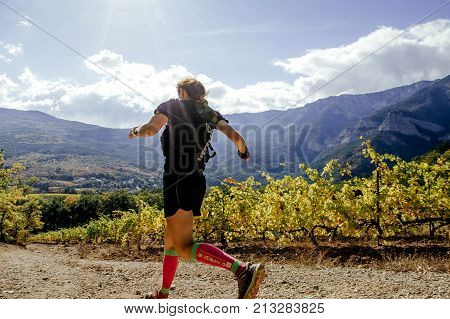 Crimea Russia - October 13 2017: girl runner athlete running on sun rays valley vineyard during Crimea Х Run