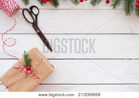 Gift wrapping. Hand crafted Christmas present gift boxes and tools on white wooden background. Flat layout top view composition copy space design.