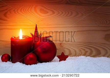 Avent candle and christmas decoration isolated on wood background. Christmas background with snow, candle and red star.