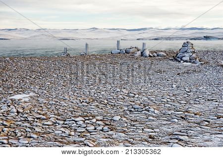 The pebbles on the lake Baikal beach in winter under the ice, Russia