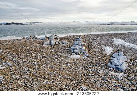 The pebbles on the lake Baikal beach in winter under the ice, Russia