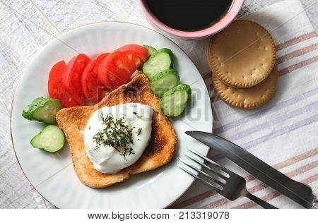 Breakfast. Egg poached vegetables coffee and biscuits on the table.