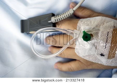 Close Up Of Spo2 Sensor (peripheral Capillary Oxygen Saturation) And Iv Drip On Patient's Hand At Th