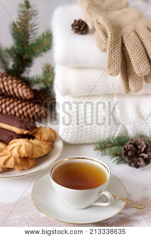 Winter Composition With Tea And Biscuits In The Background Of A Rug Or Pullover, Cones And Fir Branc