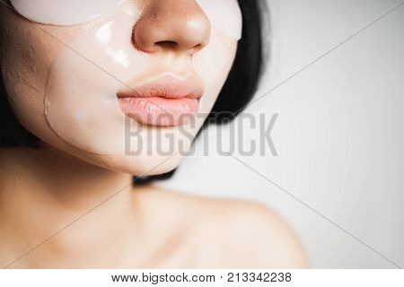 A young girl with black hair moisturizes her face with silicone patches