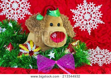 New Year Toy Dog Surrounded By Decorative Christmas Elements And Fir Branches On Red Background