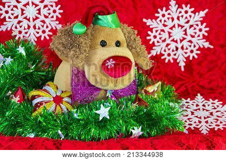 New Year Toy Dog Surrounded By Decorative Christmas Elements And Fir Branches On Red Background