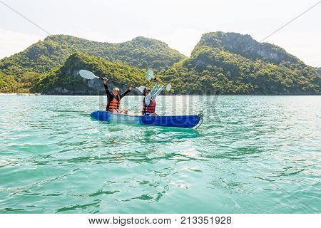 Two women are mother and daughter. Travel by boat with a kayak happy on the sea under the bright summer sky front of Ko Wua Ta lap islands 