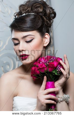 beautiful brunette young woman in white wedding gown. bride with fashion hairstyle. studio shot.