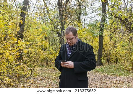 Smiling Young Man Reading Sms On Phone. A Man Checks The Mail On The Phone. \
