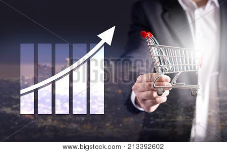Statistics analytics and financial report. Success and growth concept. Growing graph. Business man holding miniature shopping cart. Double exposure.