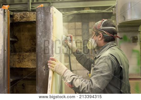 LIPETSK, RUSSIA - JUNE 15, 2017: Lipetsk Machine Tool Plant. The worker polishes the primer layer. Work on the preparation of the machine bed for subsequent painting.