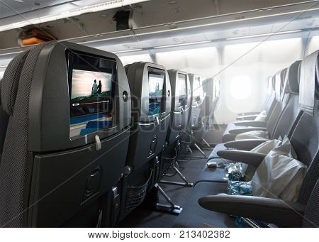 Seats waiting for passengers and take off in an airplane. Empty plane interior before flight and departure. Watching movie on an aircraft. Imaginary film playing on a video player in monitor.
