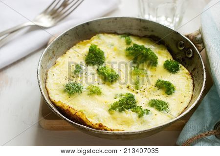 Omelette with broccoli and cheese served with bread toasts and lemonade. Selective focus.