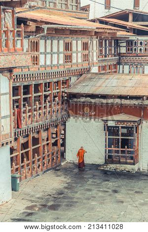 Trongsa Bhutan - September 13 2016: Bhutanese monk in traditional clothes standing in the backyard of Trongsa Dzong Bhutan