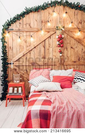 Xmas in morning bedroom. Double bed In christmas Interior on wood wall background.