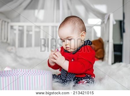 Beautiful baby sitting and playing toy. Bedroom. The concept of childhood and education.