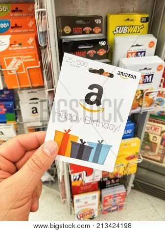 MONTREAL CANADA - NOVEMBER 7 2017: Happy Birthday Amazon gift card in a hand on gift cards background. Amazon is an American electronic commerce and cloud computing company based in Seattle USA