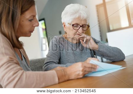 Home assistant helping elderly woman with paper work