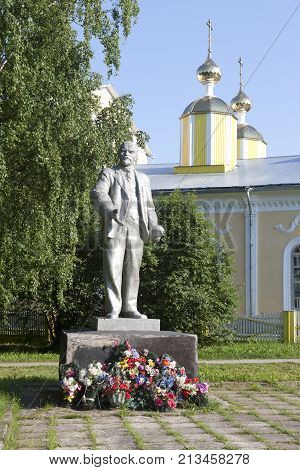 Verkhovazhye, Vologda region, Russia - June 14, 2013: Lenin monument on the background of the domes of the church in the village of Verhovazhe