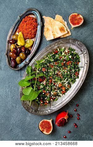 Middle Eastern traditional dinner. Authentic arab cuisine. Meze party food. Tabbouleh muhammara olives. Top view flat lay overhead