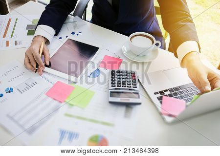 Young Business Man Working At Office With Tabletcomputer Laptopcalculatorpost It Note And Graph Data