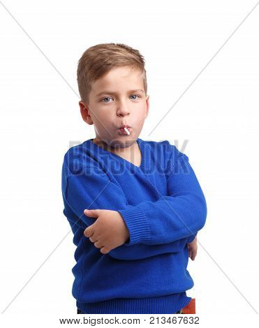 Boy in blue sweater and jeans eating lollipop and hands on chest on white isolated background