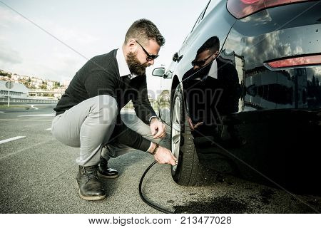 Bearded Man Checking Tire Pressure