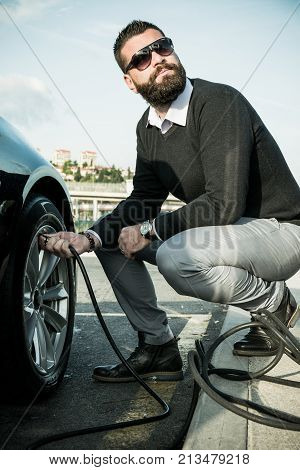 Bearded Man Checking Tire Pressure