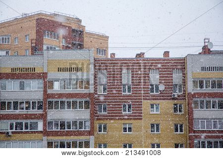 flakes of snow over the houses in the city