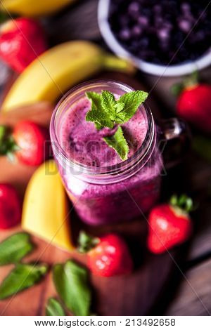 Blueberry smoothies with fruit on a wooden background
