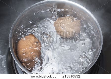 Eggs in boiling water in saucepan on electric hob