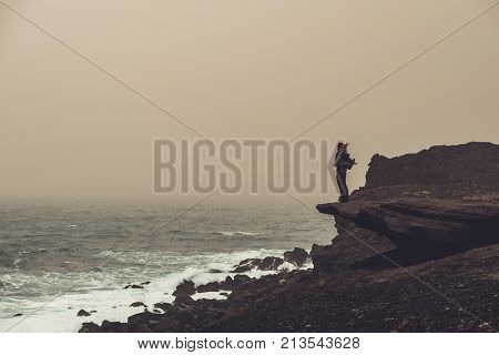 Woman standing on a cliff.