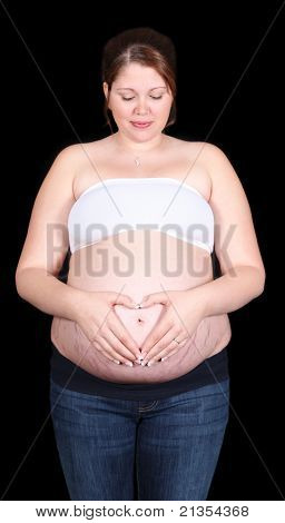 Těhotná žena s rukama ve tvaru srdce v břiše. Izolované