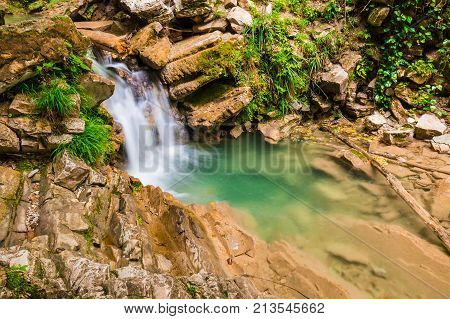 Waterfall and small lake in the ravine Chudo-Krasotka in summer day Sochi Russia