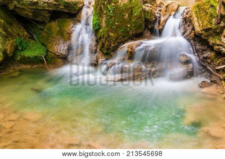 Waterfall and small lake in the ravine Chudo-Krasotka in summer day Sochi Russia