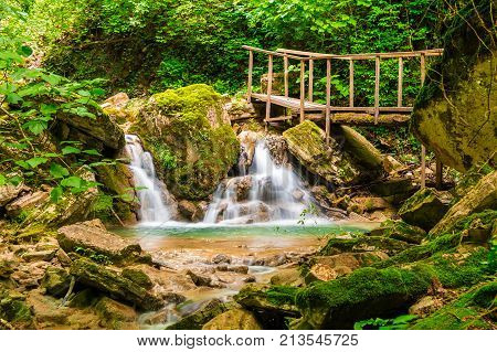 Waterfall small lake and bridge in the ravine Chudo-Krasotka in summer day Sochi Russia